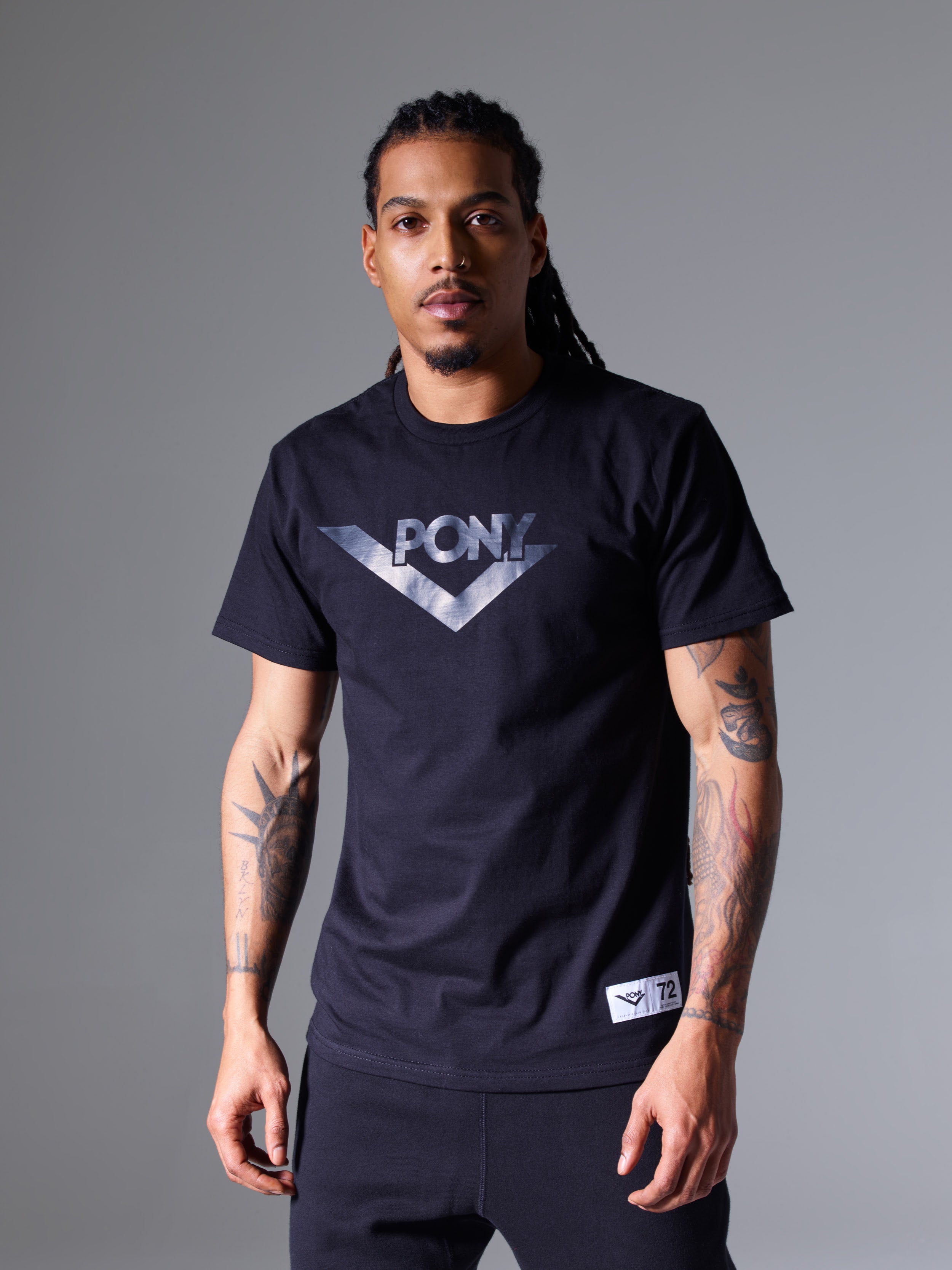 A male model wearing a PONY Classics Lockup vinyl logo t-shirt. A PONY locker label sewn to the lower right of the shirt.