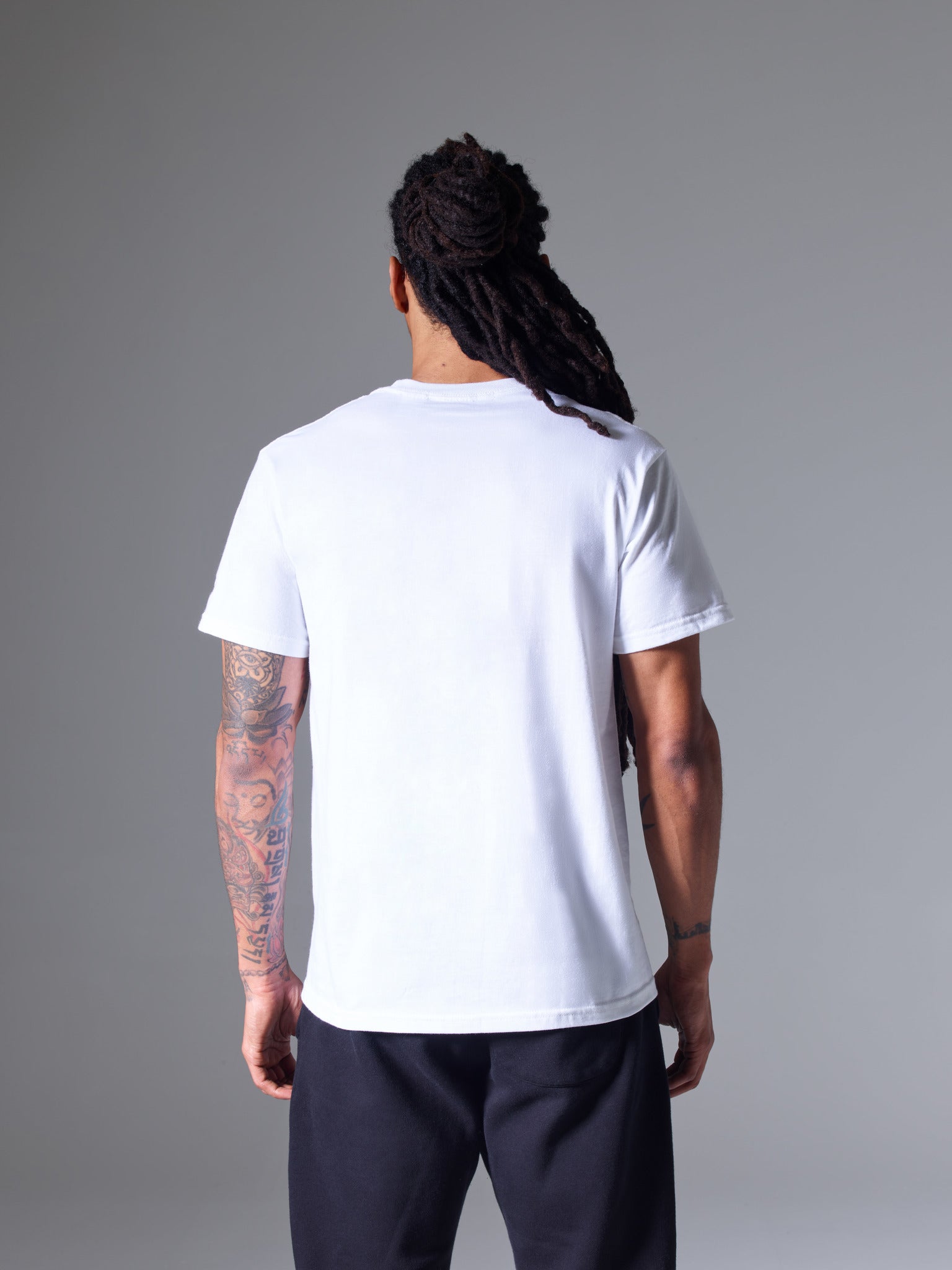 A back shot of a male model wearing the PONY Classics White T-Shirt and blue PONY Classics jogger.